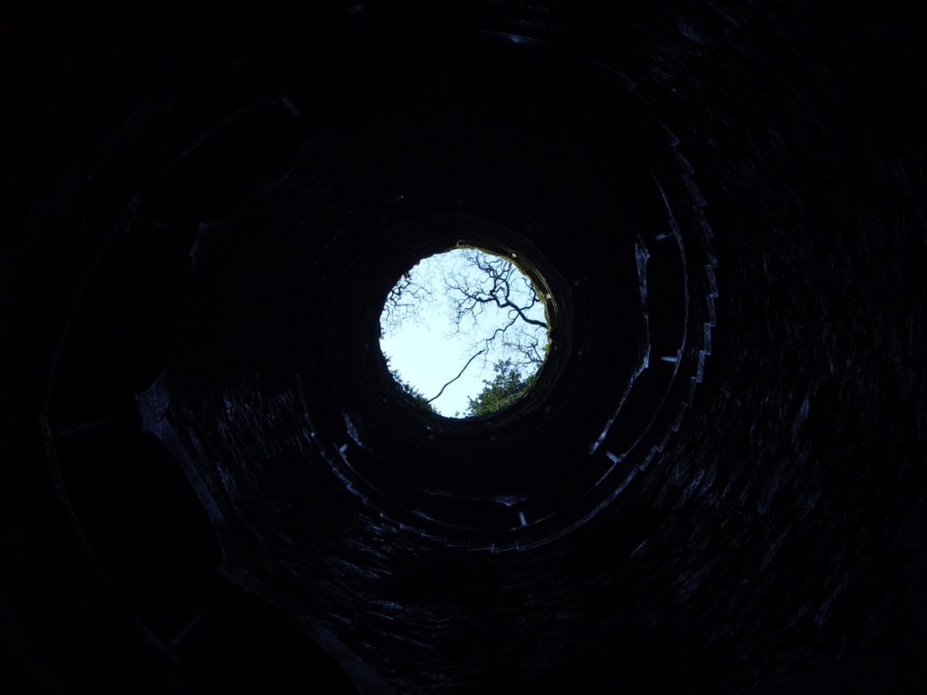 image of the view from the bottom of an old well in a well pump replacement cost blog
